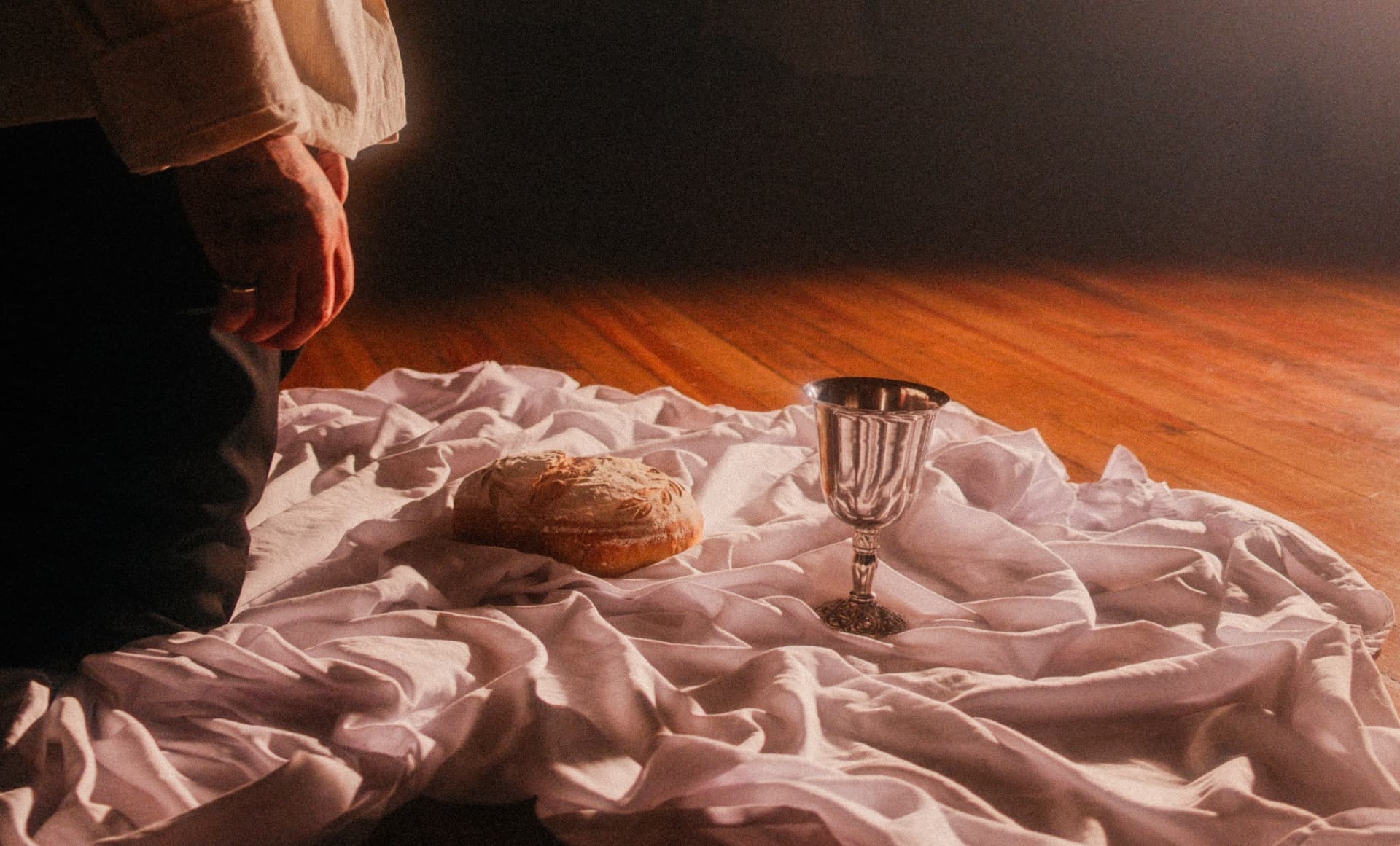 Communion bread and chalice on white cloth