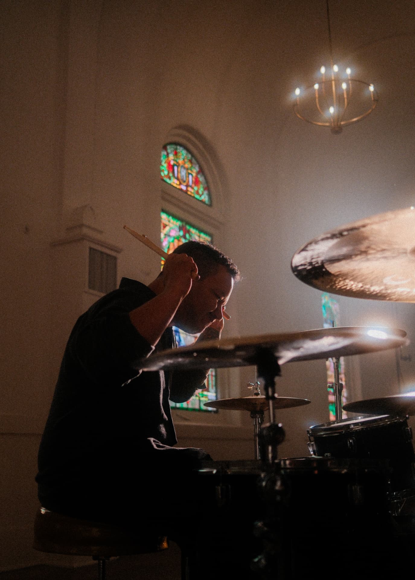 Drummer mid-action with sticks raised